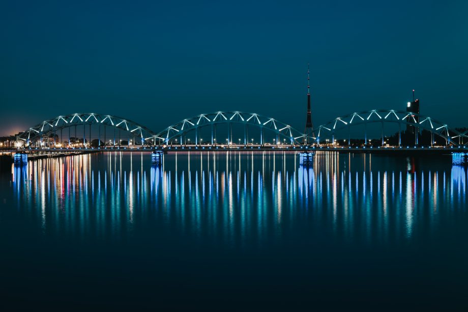 Illuminated arched bridge over river at night